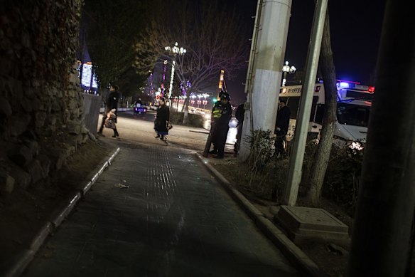 Police officers exit a police vehicle at night in Kashgar, Xinjiang autonomous region, China.