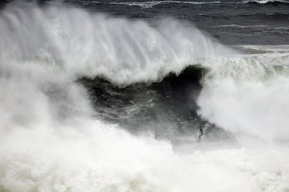 A surfer is seen braving the strong swell at Tamarama in Sydney.