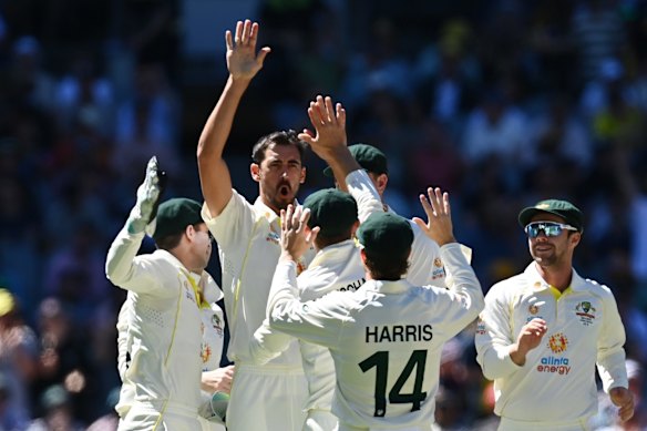 Mitchell Starc (C) of Australia celebrates with teammates after bowling out Ben Stokes of England.