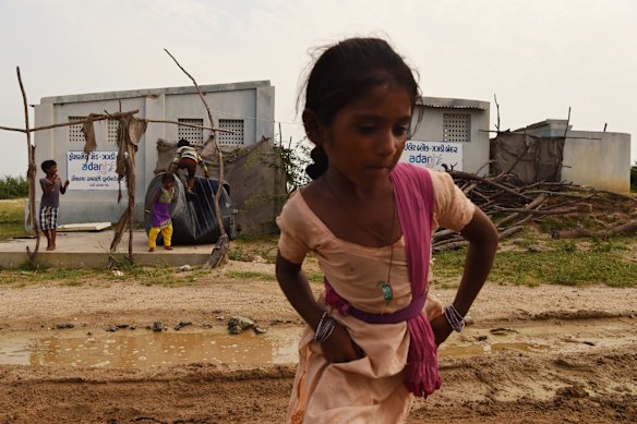 A young girl plays near a toilet block built by the Adani Group near Tragadi Bandar, a fishing settlement on the Kutch coast, in western India. In a Hindu majority country, the fisherfolk here are exclusively Muslim.