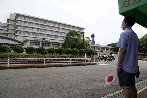 A man holds a Japanese flag outside the Nara Medical University Hospital, where Abe was brought after being shot.