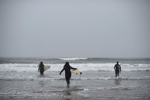 Surfers make their way into the sea in Aberdeen.