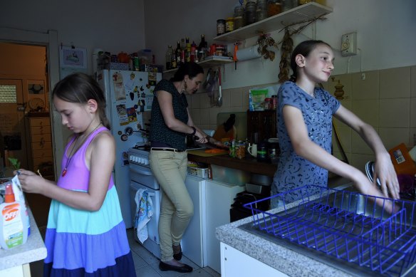 Maya Ruys 10 (left) and her sister Adelle Ruys 12 (right) in the kitchen with their mother Claire Boswell-Ruys (centre) in the apartment the family rents in Randwick, Sydney. 