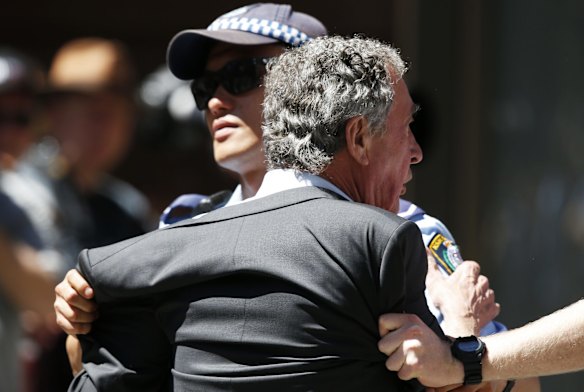A man is removed from the perimeter of the siege at Lindt Chocolat Cafe.