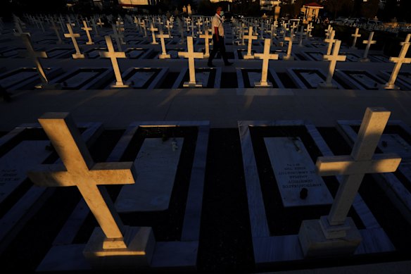 A man walks by the graves of soldiers killed in the 1974 Turkish invasion of Cyprus in the Tymvos Macedonitissas military cemetery during the 47th anniversary in the divided capital of Nicosia, Cyprus.
