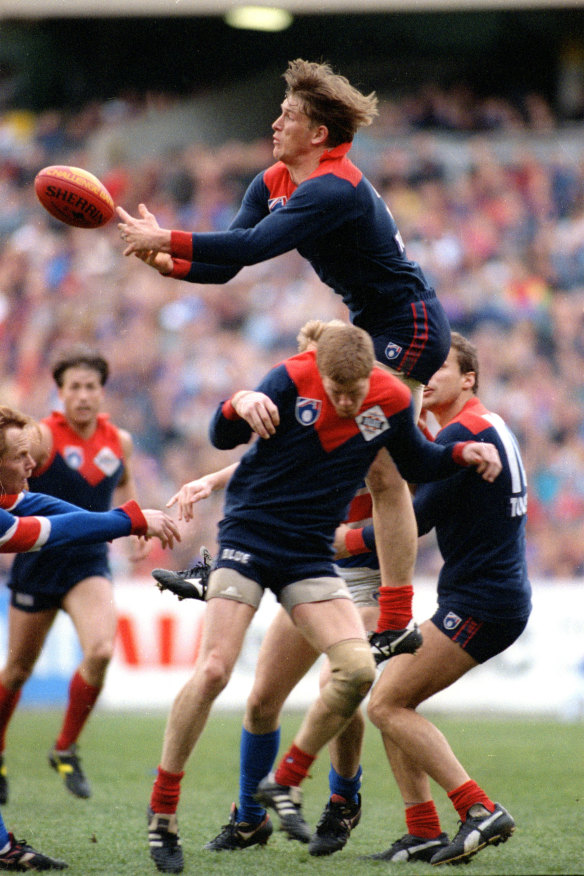 Demon high flier David Schwarz soars over teammates Glenn Molloy and Martin Pike.