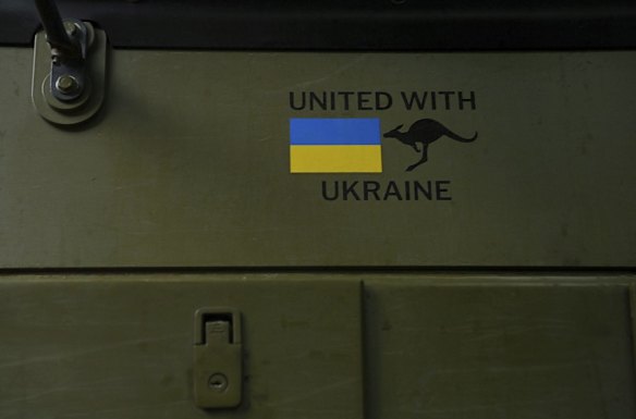 The words "United with Ukraine" are painted on the side of a Bushmaster used by a Ukrainian armed forces mechanised infantry unit.
