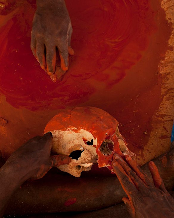 July 19th 2011, Traditional owners cover the remains of their ancestors in red ochre as human remains are finally reurned to their ancestral home in Gunbalanya for ceremonial reburial after over 60 years in the posession of the Smithsonian Institution after being collected during a combined Australian and American expedition to Arnhem Land in 1948.