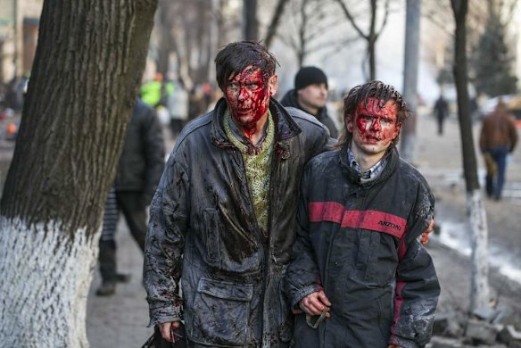 Wounded people walk after clashes with riot police in central Kiev February 18, 2014. Ukrainian riot police advanced on the heart of 12-week-old protests against President Viktor Yanukovich on Tuesday and security forces set a deadline to end disturbances after at least five protesters were reported killed in a day of clashes.