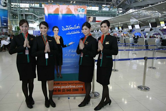 Thai transsexuals flight attendants, from left to right, Chayathisa Nakmai, Dissanai Chitpraphachin, Nathatai Sukkaset and Phuntakarn Sringern pose for photograph at a check-in counter for PC Air at Suvarnabhumi international in Bangkok.