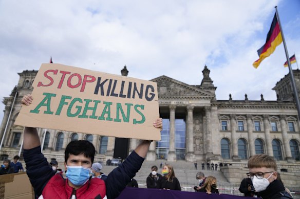 A man holds a poster during a demonstration in Berlin, Germany. Several hundreds of people attend a demonstration to support an air bridge to bring people out of the Taliban controlled country. 