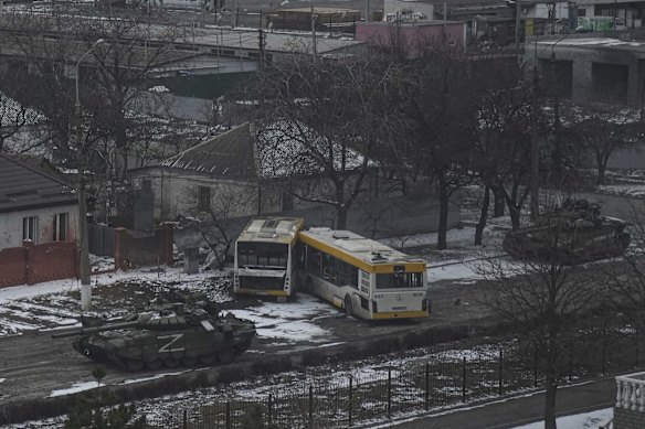 Russian tanks move down a street on the outskirts of Mariupol, Ukraine.