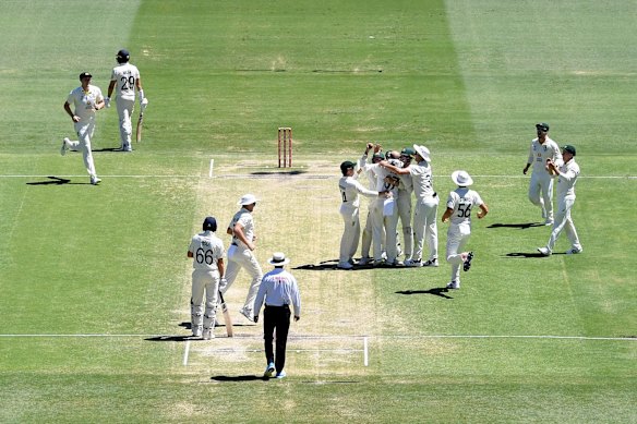 Nathan Lyon of Australia celebrates taking his 400th test wicket after dismissing David Malan of England for 82 runs during day four of the First Test Match in the Ashes series between Australia and England at The Gabba on December 11, 2021 in Brisbane, Australia.