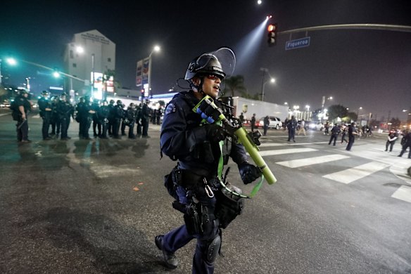 Police officers clear a street during a protest on election night in Los Angeles. 