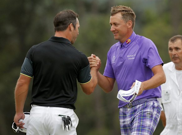 Paul Casey (L) and Ian Poulter of Great Britain shake hands after finishing out on the 18th.