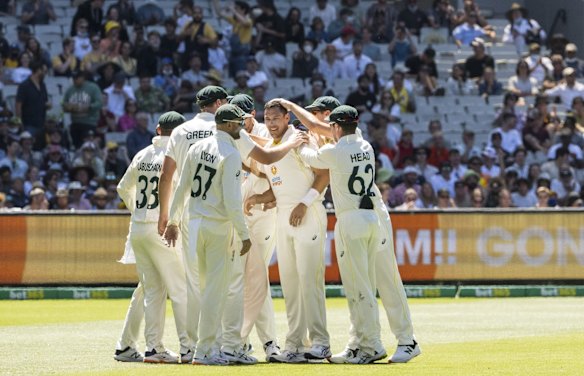 The Australian team congratulate Scott Boland after his match winning performance.