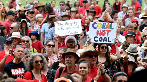 Anti-Adani coal mine protestors are seen rallying at Crosby Park in Brisbane