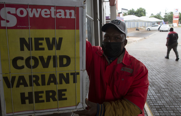 A petrol attendant stands next to a newspaper headline in Pretoria, South Africa on Saturday.