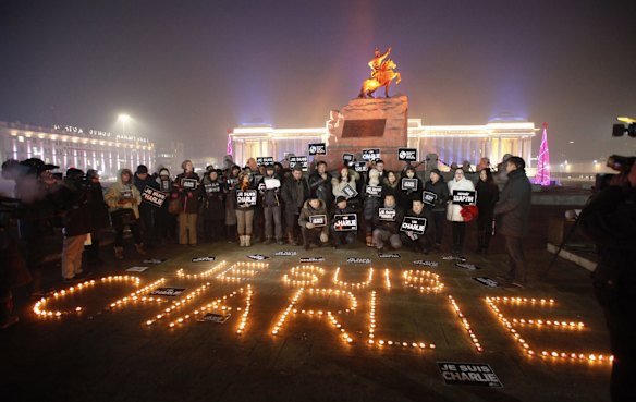 Mongolian journalists holding cards pose next to candles which were placed to form the phrase "I am Charlie" as they pay tribute to the victims of a shooting by gunmen at the offices of French weekly newspaper Charlie Hebdo in Paris, during a candlelight vigil at Genghis Square, formerly Sukhbaatar Square, in Ulan Bator January 9, 2015.