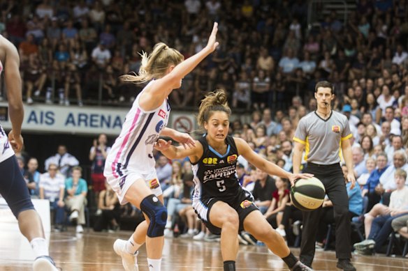 The Canberra Capitals' Leilani Mitchell works her way around the Adelaide Lightning's Aimie Clydesdale. 