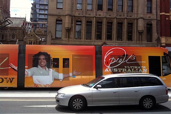 Tram spotting .... A tram passes Federation Square on Flinders Street, where thousands of people are waiting for the real thing, some of them camped out since early this morning.