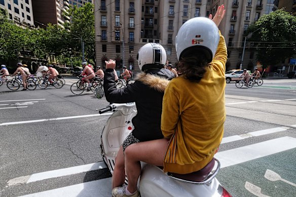 Spectators cheer as nude cyclists ride through the city during the World Naked Bike Ride in Melbourne.