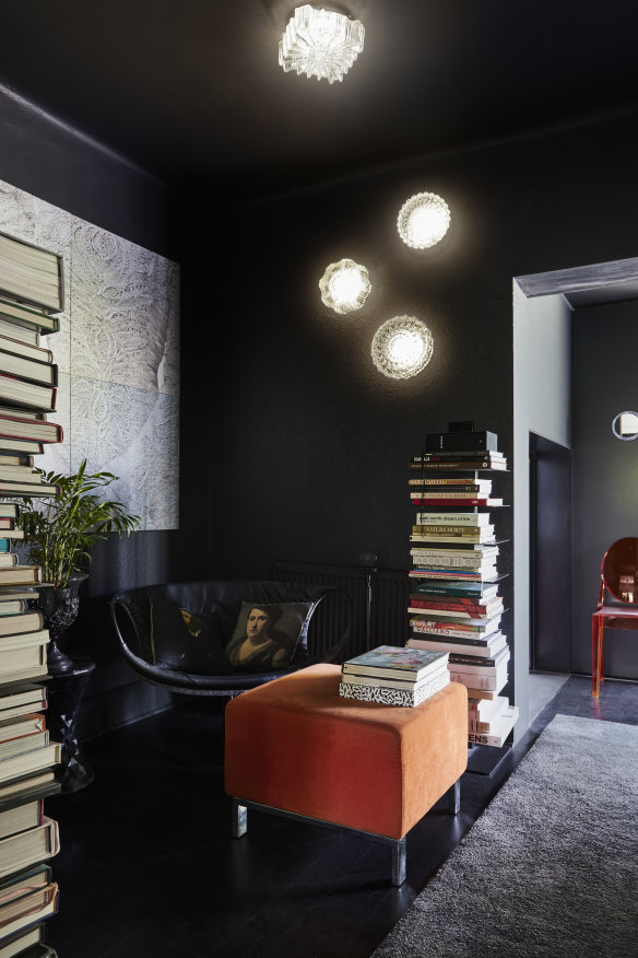 In the intimate reading nook, a black leather “Smock” chair by Patricia Urquiola sits beneath an artwork by Jennifer Jackson called Surfaces and Doubles.
