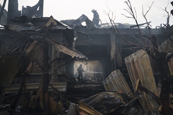 Firefighters work to extinguish a fire at a house after a Russian attack in Kharkiv.