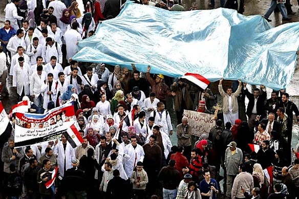 Medical students join anti-government protests in Egypt while protecting themselves from the rain at Tahrir Square.