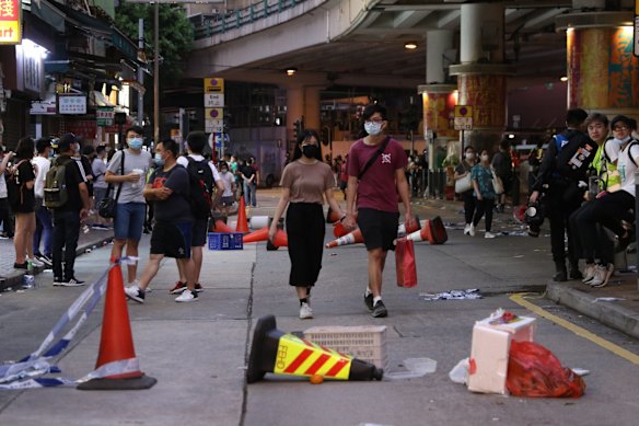 People move around the debris of roadblocks set by protesters during a protest against a planned national security law in the Wan Chai district in Hong Kong, China.