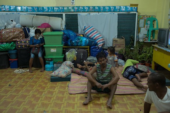 Families gather inside the temporary evacuation center at Balzain East Elementary School.