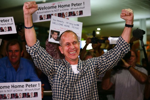Al-Jazeera journalist Peter Greste punches the air on his arrival.