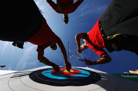 Team members from Spain retrieve their arrows from the target during the Men's Team Eliminations.