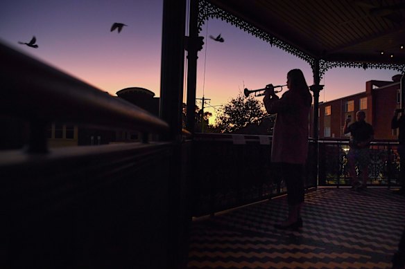 Bugler Sarah Brown aged 23yrs plays The Last Post from the balcony of The Royal Hotel in Leichhardt to a small group of people at dawn on ANZAC Day. 