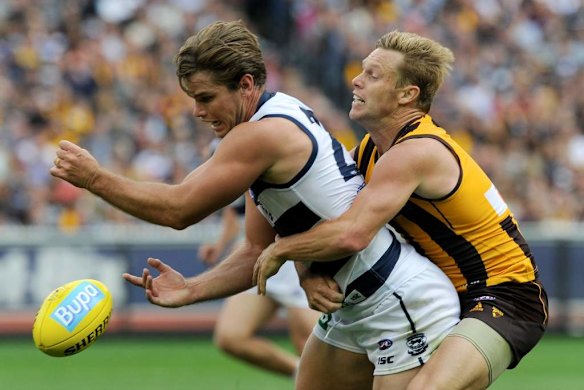 Geelong's Tom Hawkins is tackled by Sam Mitchell.