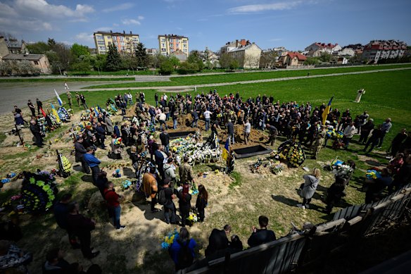 A general view as family members mourn at the gravesides during the simultaneous burial of three soldiers in the Field of Mars at Lychakiv cemetery in Lviv, Ukraine.