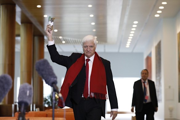 Bob Katter MP buys $19,000 worth of gold off Edward Cummings during a press conference about the restriction on cash bill at Parliament House in Canberra.