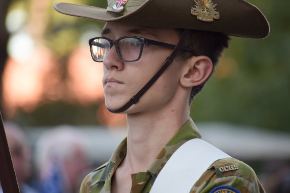 A young Army cadet stands guard next to his fellow cadets. 