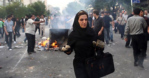 In this photograph posted on the internet, an Iranian woman carries rocks at an anti-government protest in Tehran, Iran Saturday June 20, 2009. (AP Photo)
