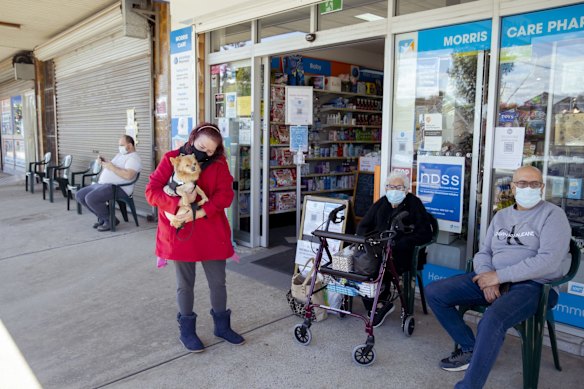 Michelle Hamilton with her dog Chi Chi, and Nawal Metias with her son Hany Metias, wait for 15 minutes after they received their first jab at Veronica Nou's Pharmacy in St Marys, which is now delivering the AstraZeneca COVID-19 vaccine.