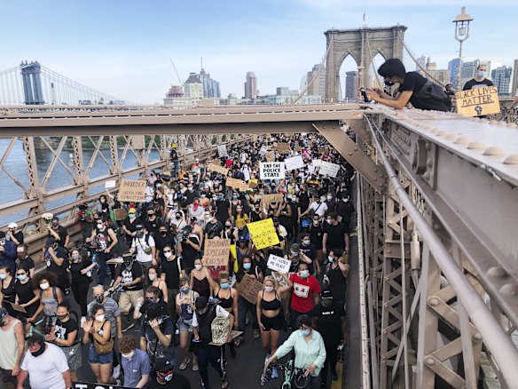 Demonstrators march on the Brooklyn Bridge after a memorial service for George Floyd.