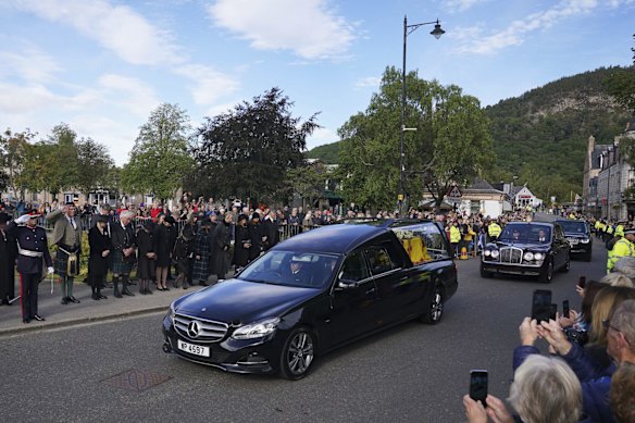 Members of the public line the streets in Ballater, Scotland, as the hearse carrying the coffin of Queen Elizabeth II passes through.