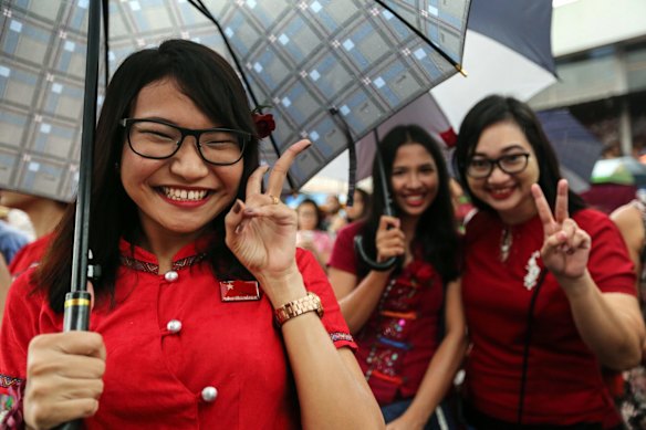 National League for Democracy (NLD) party supporters pose for a photograph as they celebrate first elections results outside the party headquarters in Yangon, Myanmar.
