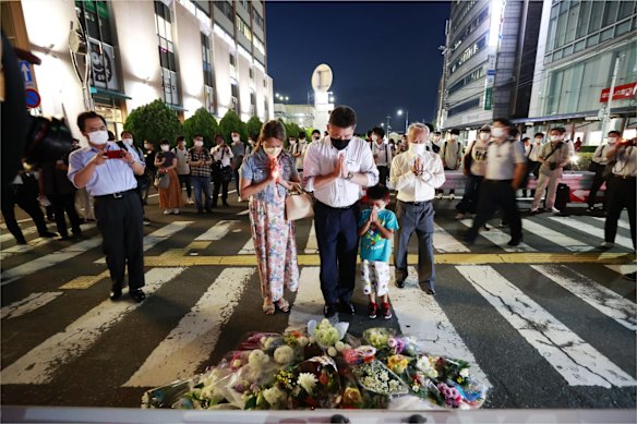 People pray at a makeshift memorial at the scene of the shooting.