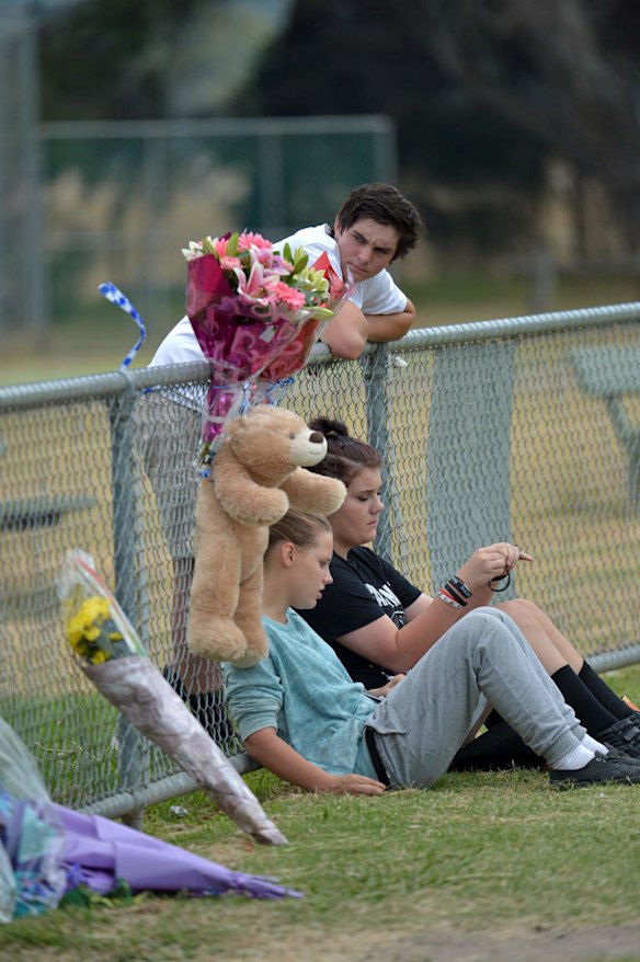Friends arrive at the Tyabb oval to place flowers.