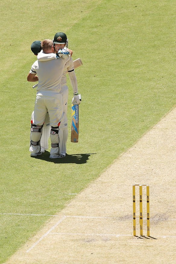 David Warner celebrates making his century with Michael Clarke.