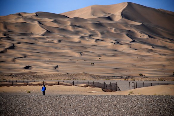 Dunes rise above the Mogao Caves, near Dunhuang, China. Photo: Conrad Walters.
