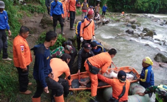 Rescuers were still on the scene hours after the bus carrying about 50 people plunged off a ravine and into a river in Indonesia's South Sumatra province.