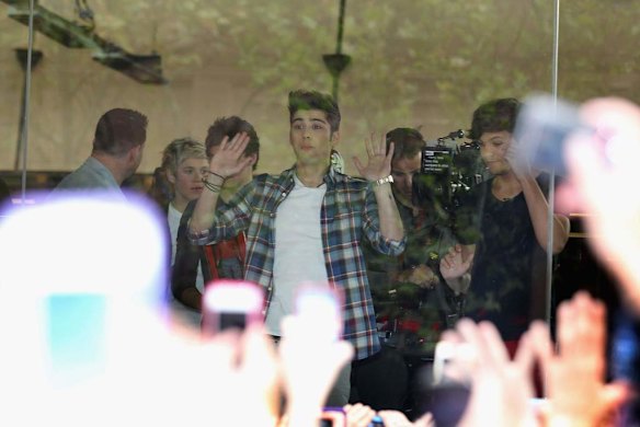 Two handed wave ... One Direction look out to fans during their visit to Sunrise Martin Place studio.