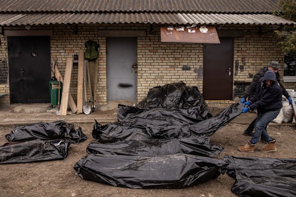 Relief workers move some of the bodies of civilians killed in and around Bucha. 